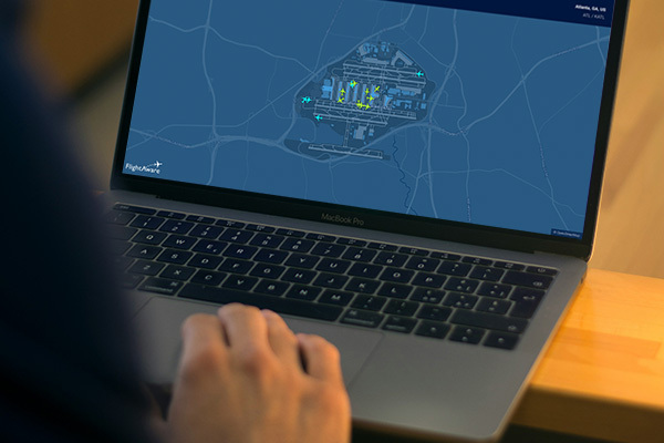 A user viewing FlightAware's surface map on a laptop.